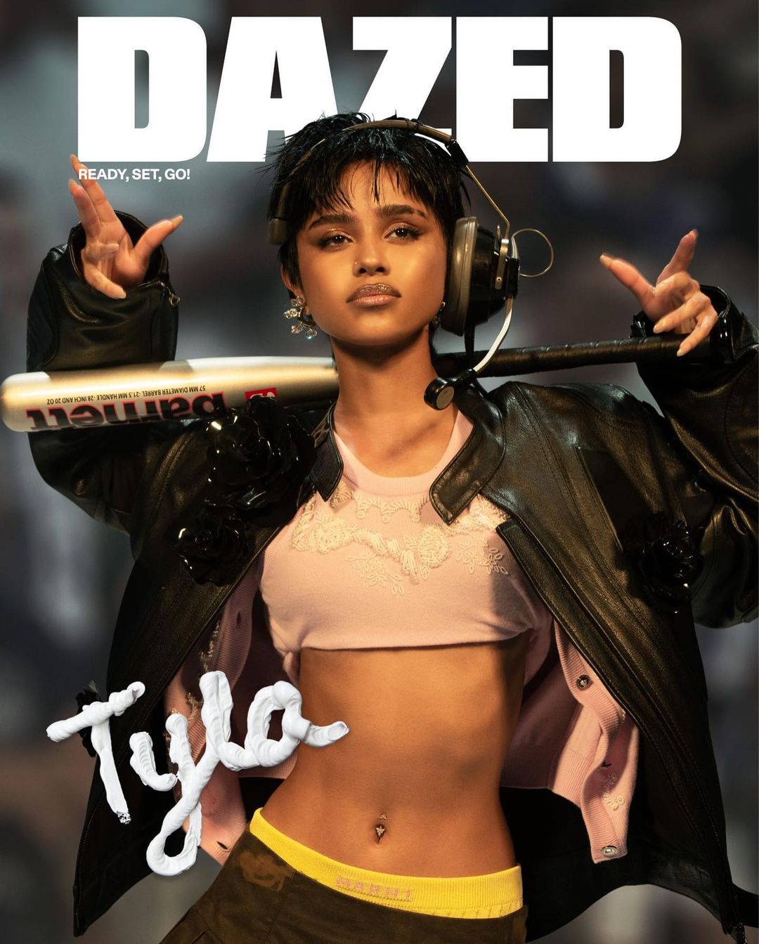 Dazed cover featuring Tyla in a black jacket and crop top holding a baseball bat, showcasing fashion and celebrity lifestyle.