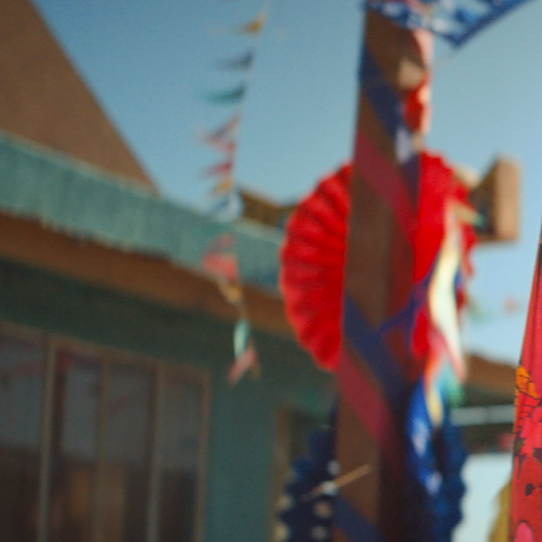 Decorated building exterior featuring colorful pennants and streamers against a clear blue sky creating a festive atmosphere.