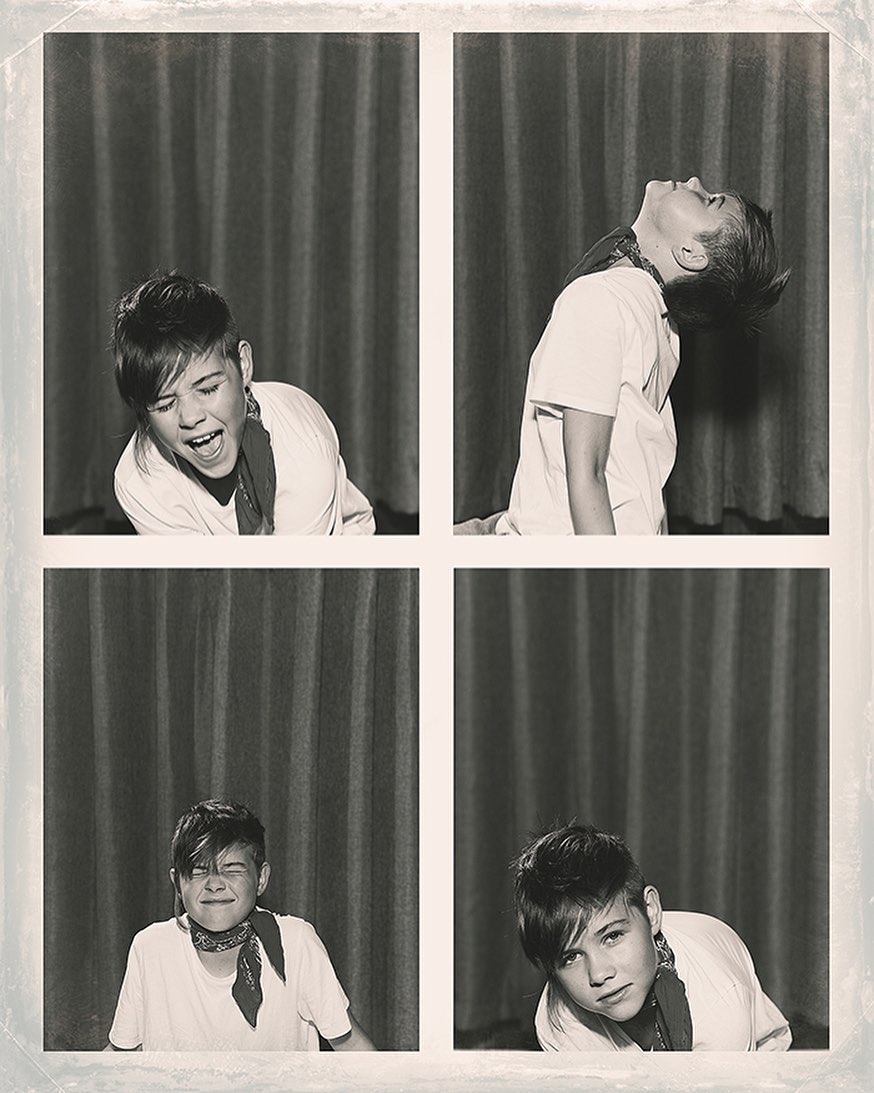 Monochrome photo booth style image featuring a young person in four different poses with a curtain backdrop, creating a vintage feel.