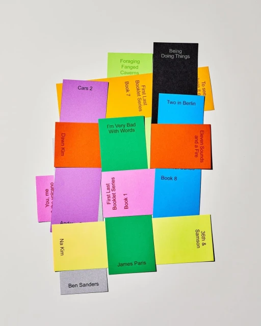 Collection of colorful paper notes stacked and arranged, each with unique printed text, set against a plain white background.