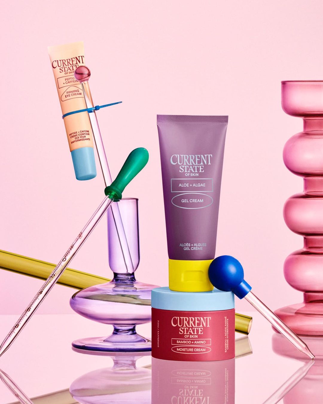 Still life shot of three Current State skin care products stacked on glass pedestals, including eye cream, gel cream and moisture cream.