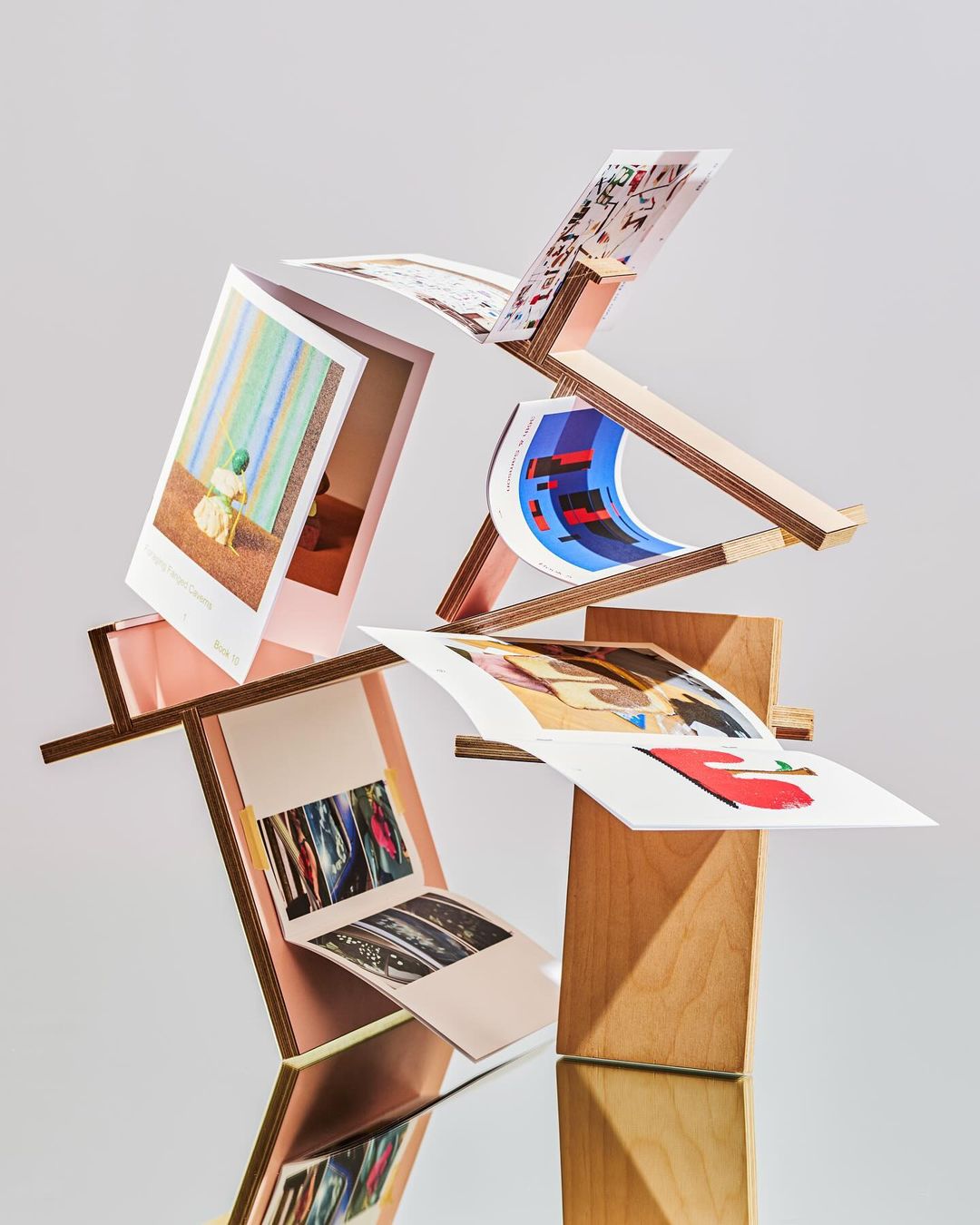 Stack of art cards arranged on wooden stands against a grey gradient background, emphasizing design and modern art elements.