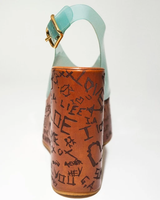 Platform sandal shoe with light-blue straps and brown wooden block heel adorned with handwritten-style inscriptions throughout.