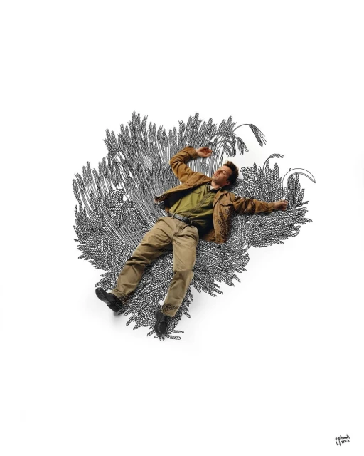 An adult male lies prone in a field of illustrated wheat stalks, wearing a brown jacket, olive shirt, and tan pants on a white background.