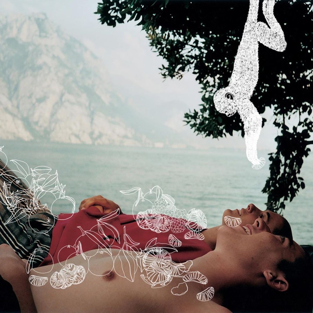 Illustration of two people reclining near a body of water and mountains, with a drawing of an animal and fruit. 