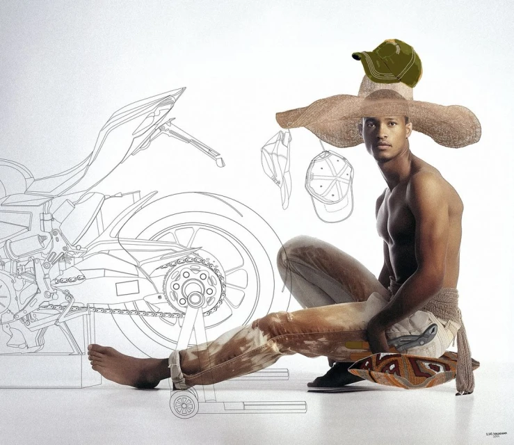 Man in jeans and a large hat sitting beside a motorcycle schematic drawing, wearing a crocheted belt and sandals against a plain white backdrop.