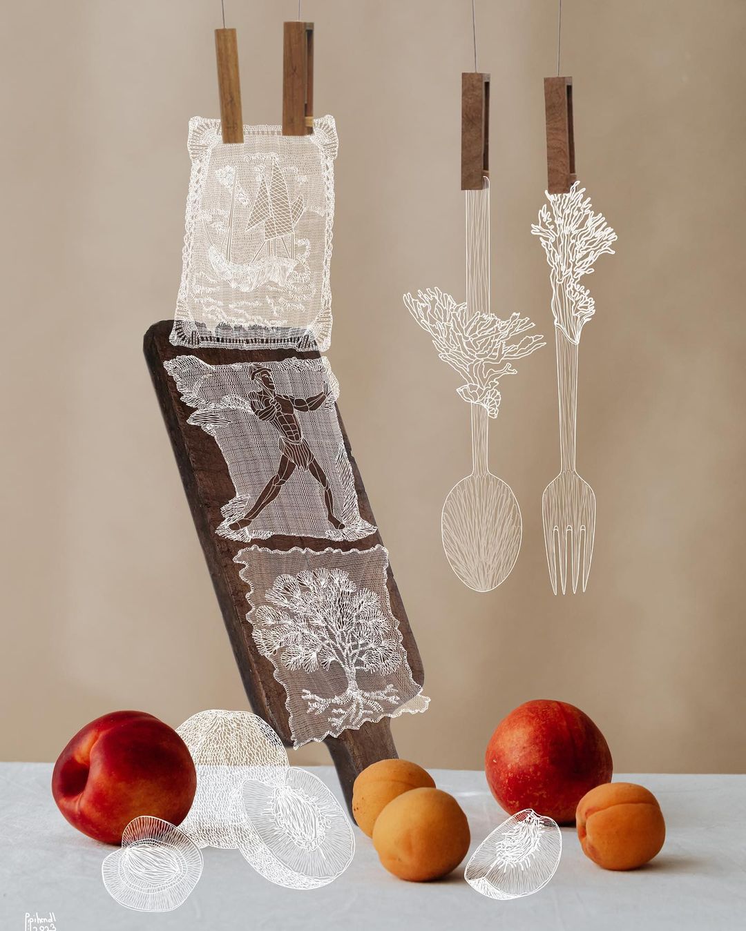 Still life of peaches, apricots, and lace cutouts depicting an athlete, boat, and tree on a neutral background.