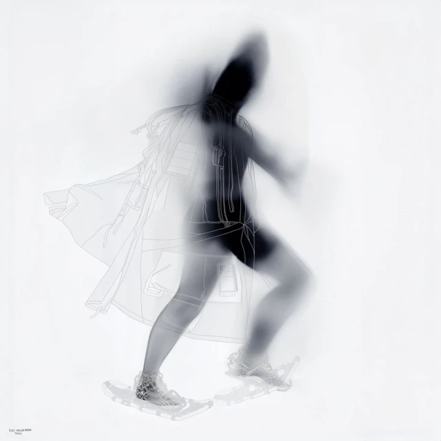 Abstract monochrome photo of person walking on snowshoes with blurred motion effect, wearing a hooded coat and dark athletic wear.