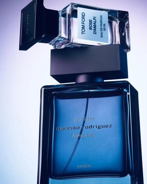 Two perfume bottles, one labeled Tom Ford Rose D'Amalfi and the other Narciso Rodriguez bleu noir parfum, are stacked on a gradient background.