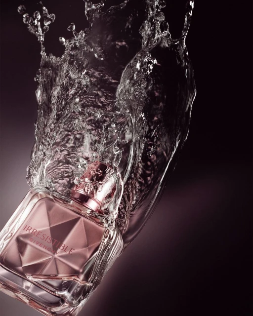 Close-up of a pink perfume bottle with faceted surface, partially submerged in clear water with splash against a dark gradient background.