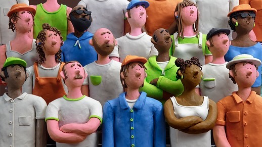 Animated claymation figures depict a diverse group of people in colorful shirts and various skin tones, creating a vibrant, textured scene.