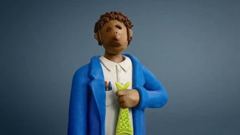Illustration of a claymation adult figure with brown curly hair in a blue coat holding a bright green fish against a dark blue background.