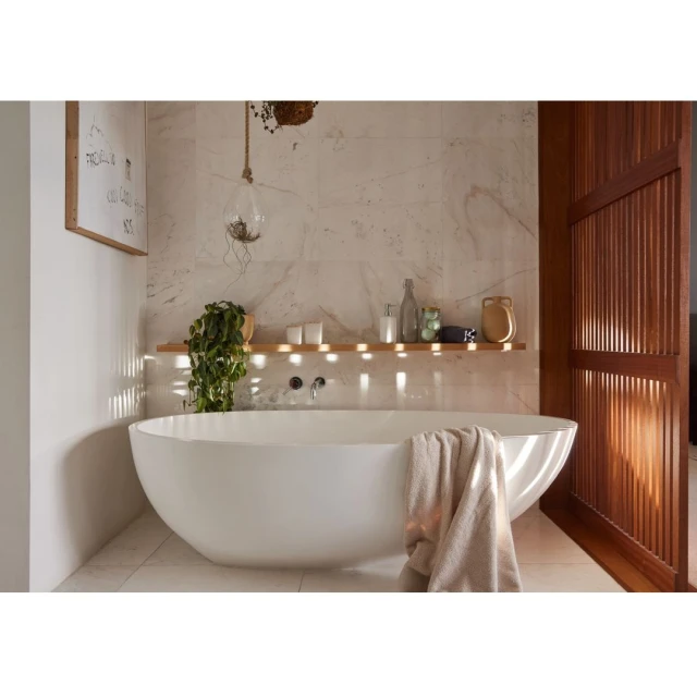 Modern bathroom interior featuring a white freestanding bathtub, marble wall, and wooden accents for a spa-like, relaxing atmosphere.