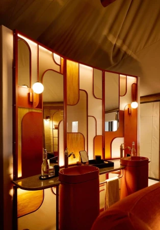 Interior bathroom design featuring double vessel sinks in terracotta, set against a mirrored backsplash with unique geometric design elements.