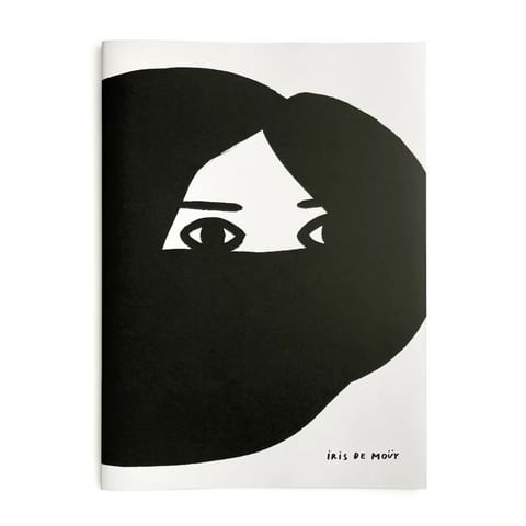 Black and white illustration of a face with eyes peering out from dark hair on the cover of a magazine or book by Iris de Moüy.