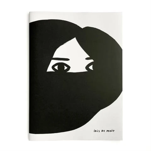 Black and white illustration of a face with eyes peering out from dark hair on the cover of a magazine or book by Iris de Moüy.