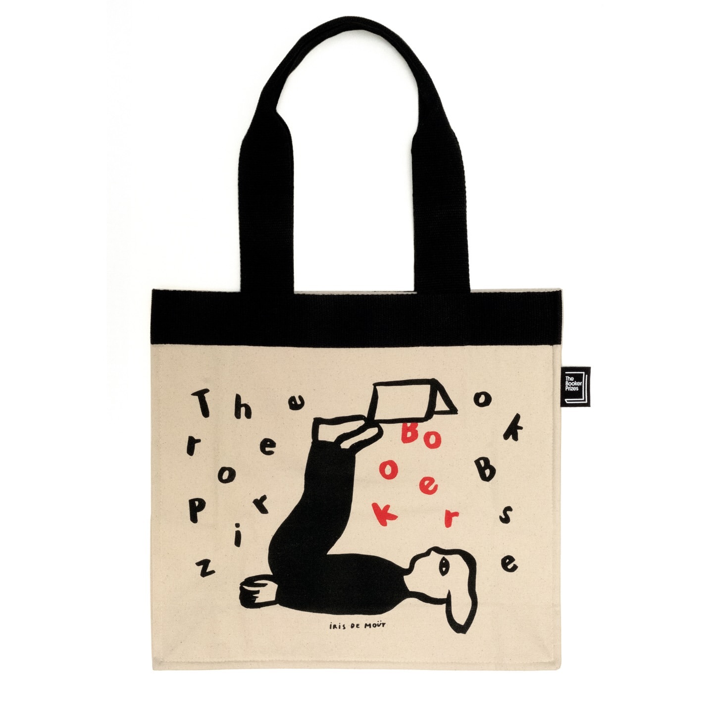 Tote bag with black handles and an illustration of a person reading a book, surrounded by stylized letters in black and red.