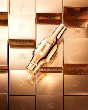 Golden Lancôme Absolue cream product and boxes, stacked as background. Beauty photography with luxury beauty brand and golden tones.