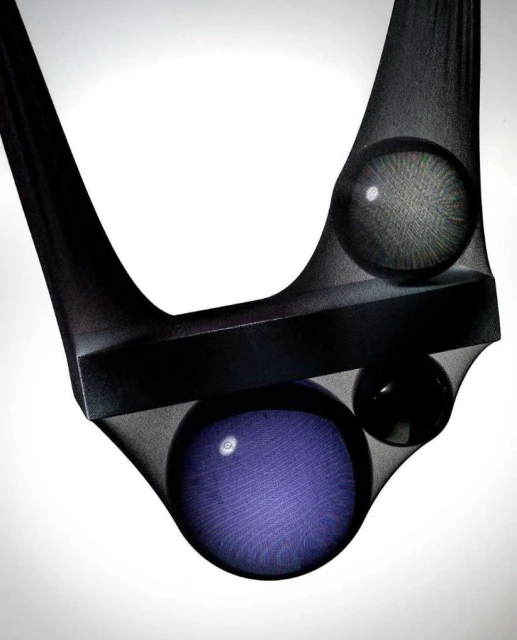 Abstract studio image of geometric shapes including a rectangle and spheres, held in place with sheer black fabric against a white background.