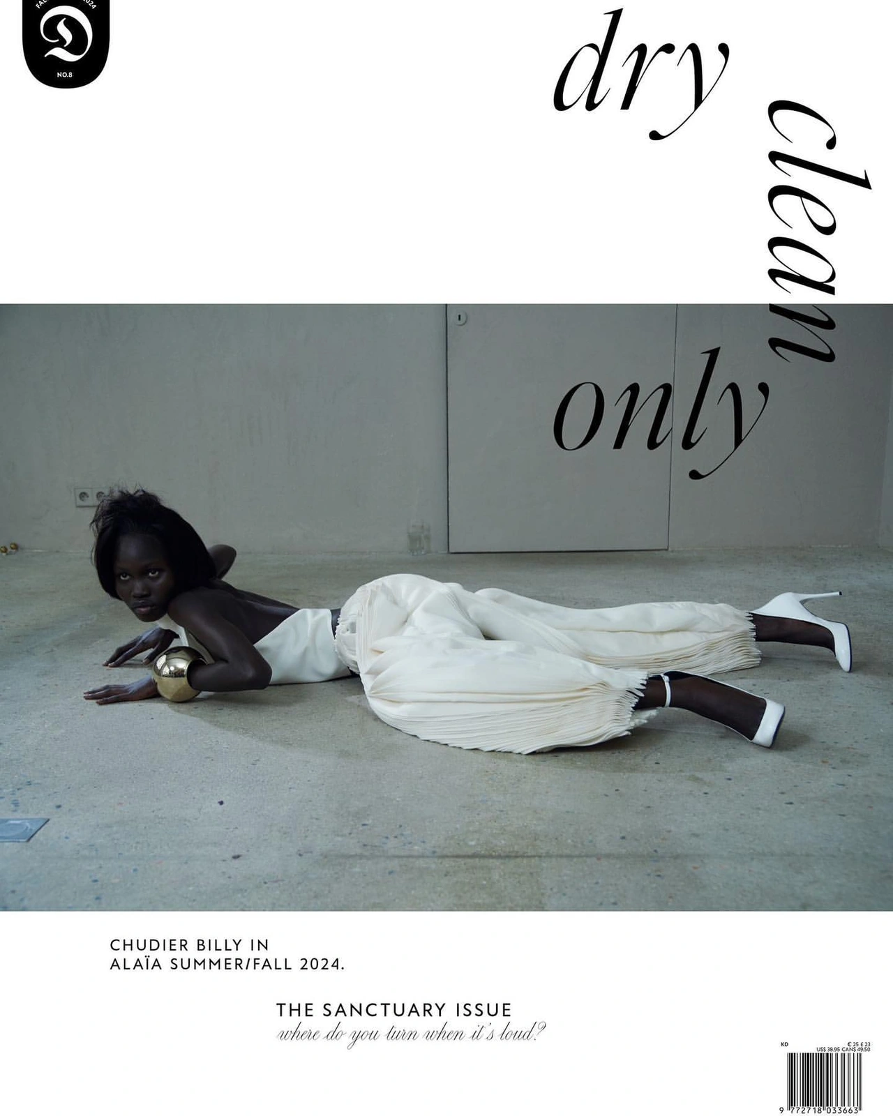Black model Chudier Billy lying flat on a concrete floor wearing white top and trousers with white high heels, photographed by Ismael Moumin.