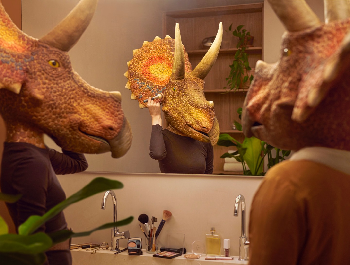 Triceratops-headed figures in a bathroom applying makeup reflected in a mirror, with bathroom sink and plant details.