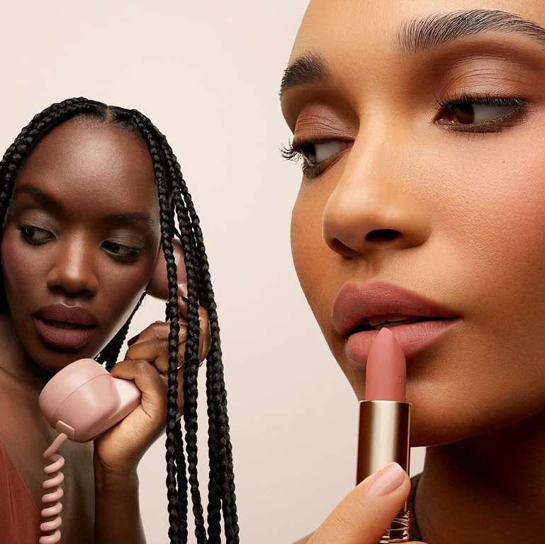 Two women of color showcase matte lipstick with a retro telephone; beauty and fashion-forward cosmetic marketing concept.
