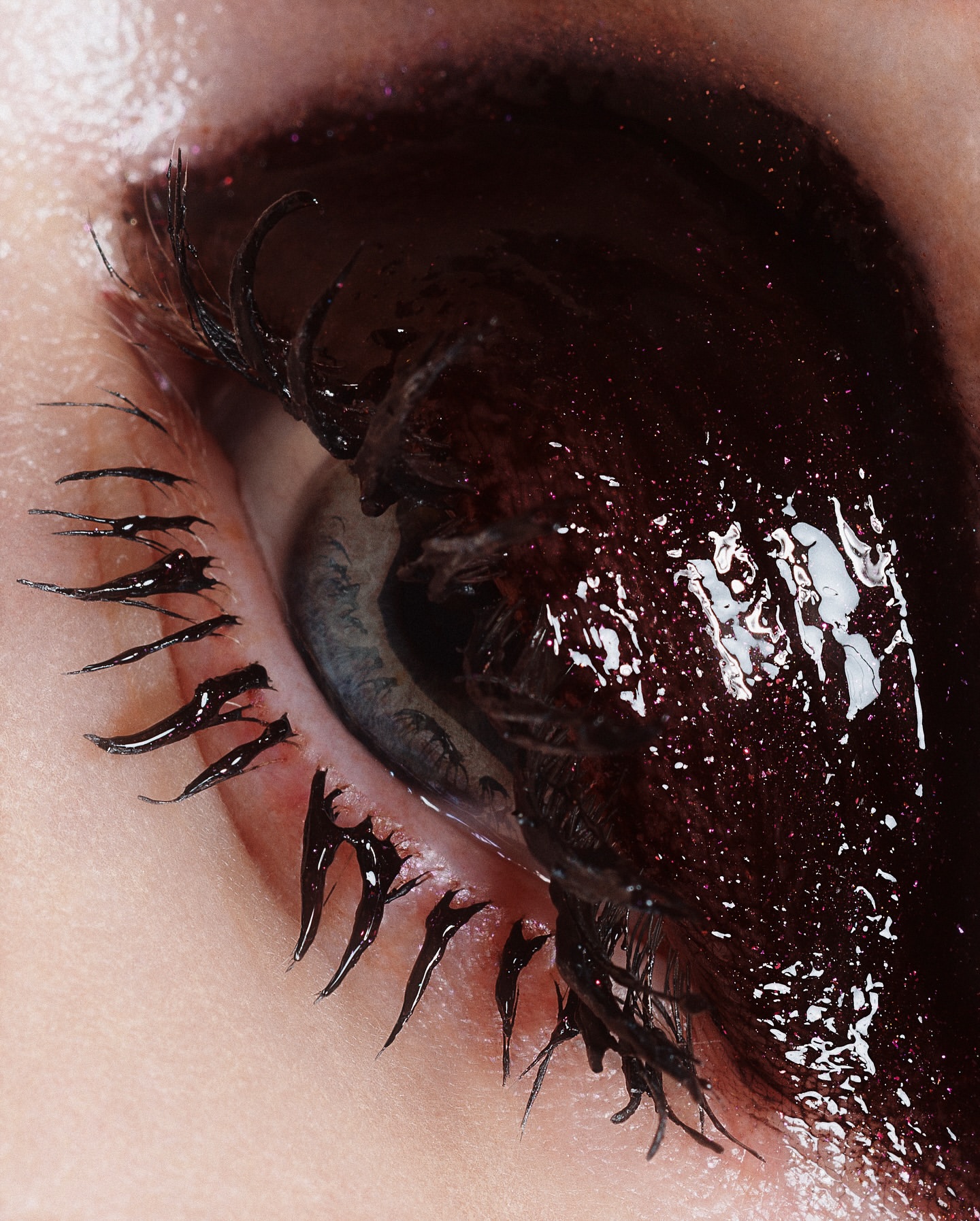 Macro shot of an adult female's eye with black eye makeup and mascara on the eyelashes, highlighting beauty and cosmetic artistry.
