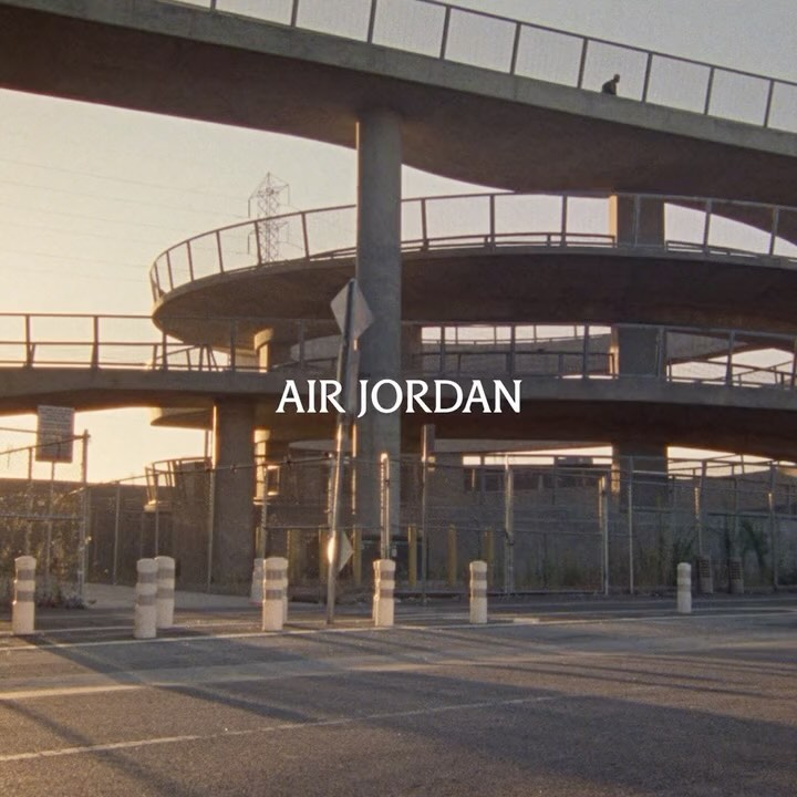 Urban view showcasing elevated highway structure and roadside barriers against golden hour light, with 'Air Jordan' branding overlay.