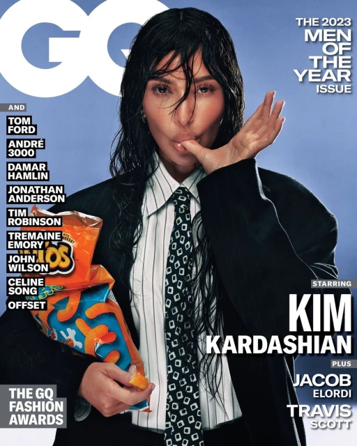 Kim Kardashian on a GQ magazine cover, 2023 Men of the Year issue, wearing a blazer, tie, and holding a bag of Takis.
