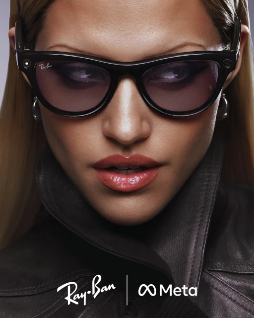 Close-up of a woman with sunglasses wearing a dark jacket, featuring Ray-Ban and Meta logos at the bottom, studio lighting.
