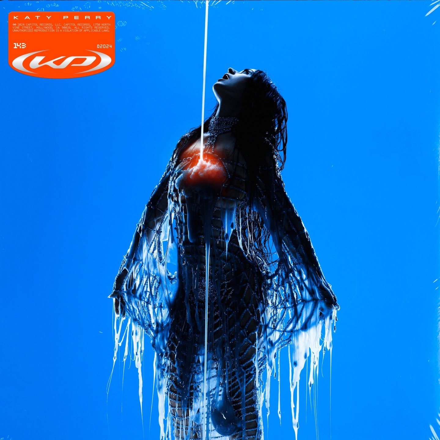 Conceptual album cover for Katy Perry features a woman in blue with glowing red heart, shot in studio against a blue background.