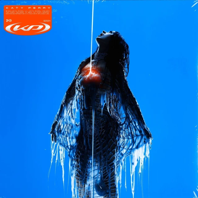 Conceptual album cover for Katy Perry features a woman in blue with glowing red heart, shot in studio against a blue background.