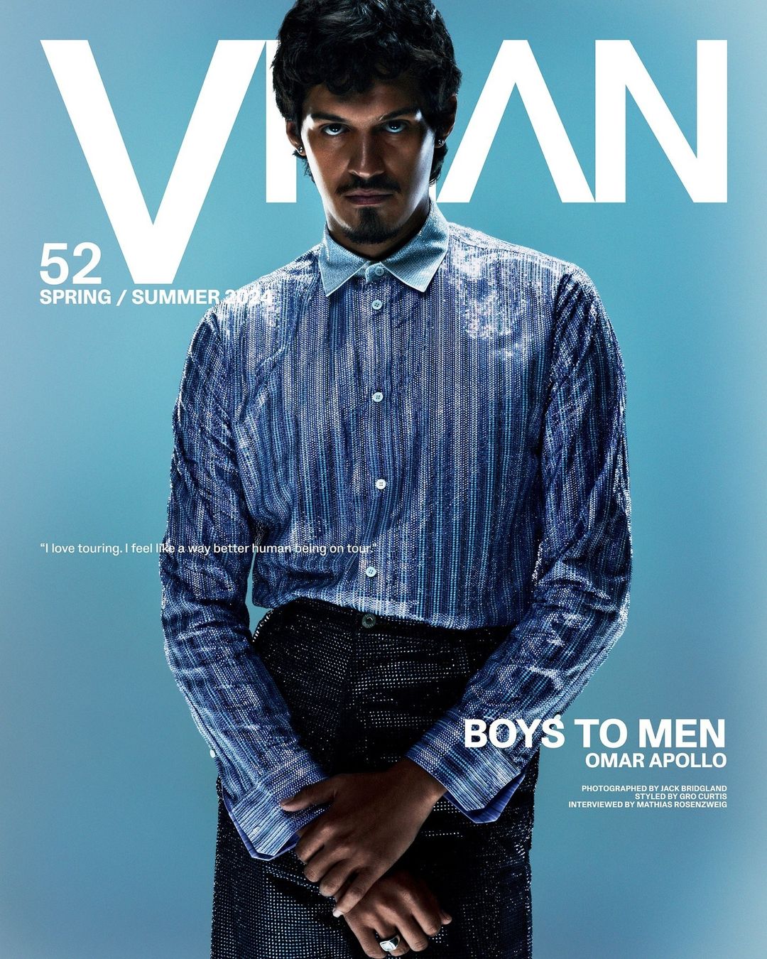 Magazine cover shot of Omar Apollo wearing a shiny blue button-down shirt and sparkling black pants against a light blue backdrop.