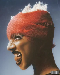 Profile portrait of a model with spiked white hair wearing a red Nike headband over their head and face against a grey background.