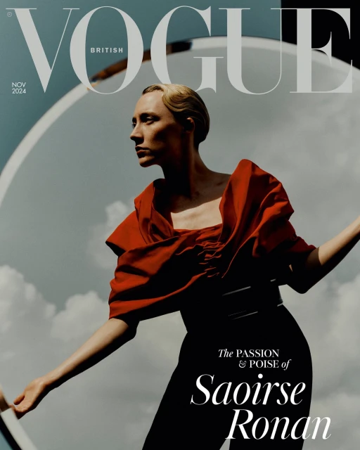 British Vogue cover featuring model Saoirse Ronan in red top and black pants, with Vogue masthead, set against cloudy sky and prop.