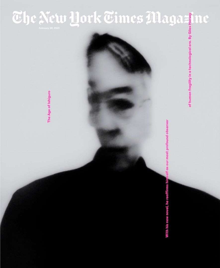 Magazine cover featuring a blurred black-and-white portrait of a person wearing glasses and a dark jacket against a light background.