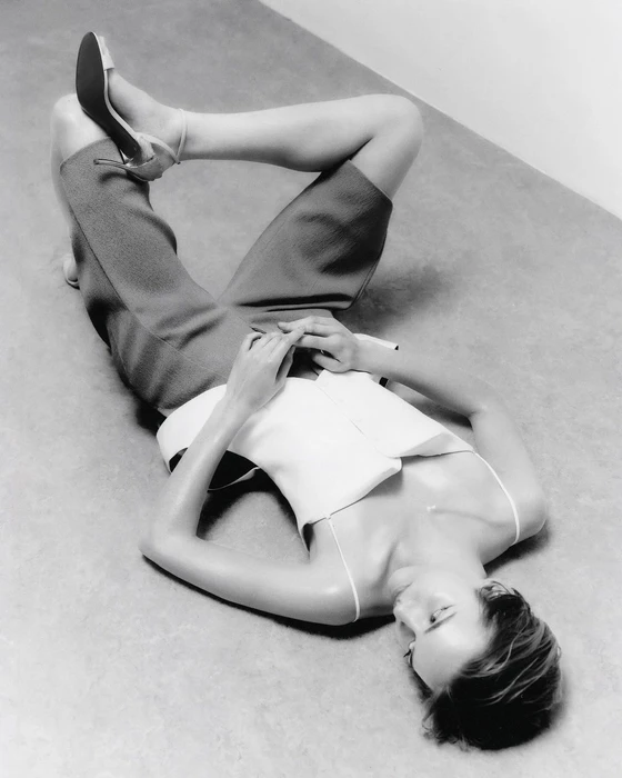 Model lying on the floor with knees up and heels in the air wearing tailored shorts and a camisole in a black and white photograph