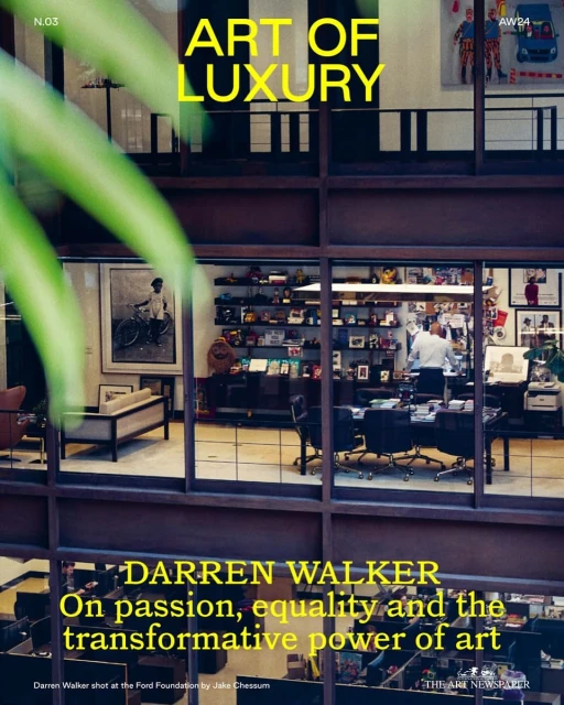 Interior magazine cover shot showcasing a modern office with people working, visible through a large window with geometric frame.