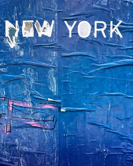Distressed blue paper wall with the words 'New York' in white lettering, creating an urban, textured background.