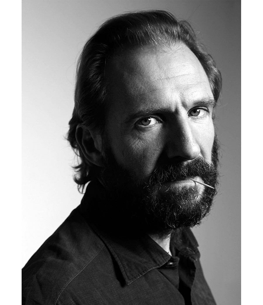 Black and white portrait of a mature adult male with a beard and dark hair, wearing a collared shirt, and holding a toothpick in his mouth.