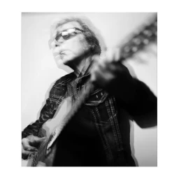 Monochrome multiple-exposure portrait of a male musician playing an acoustic guitar by photographer Jake Chessum