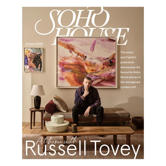 Magazine cover of Soho House featuring Russell Tovey sitting in a living room with modern decor, abstract art, and neutral color scheme.