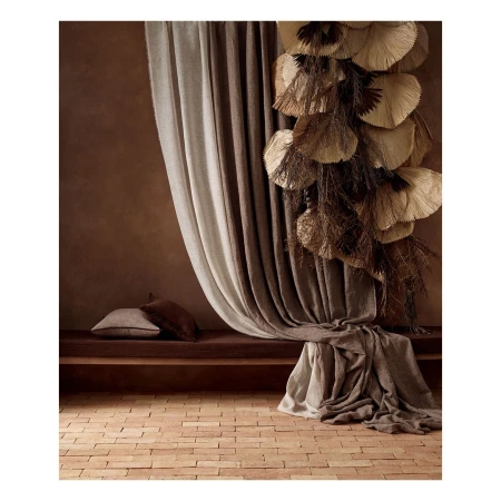 Neutral interior with beige and brown curtains, fan decorations, a cushion, and a brick floor for home decor inspiration.