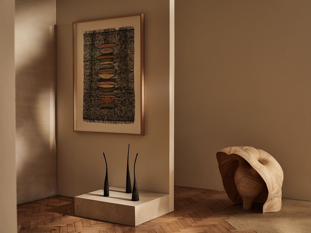 Interior photograph features an abstract art print, decorative black objects, and an abstract sculpture in a neutral color palette.