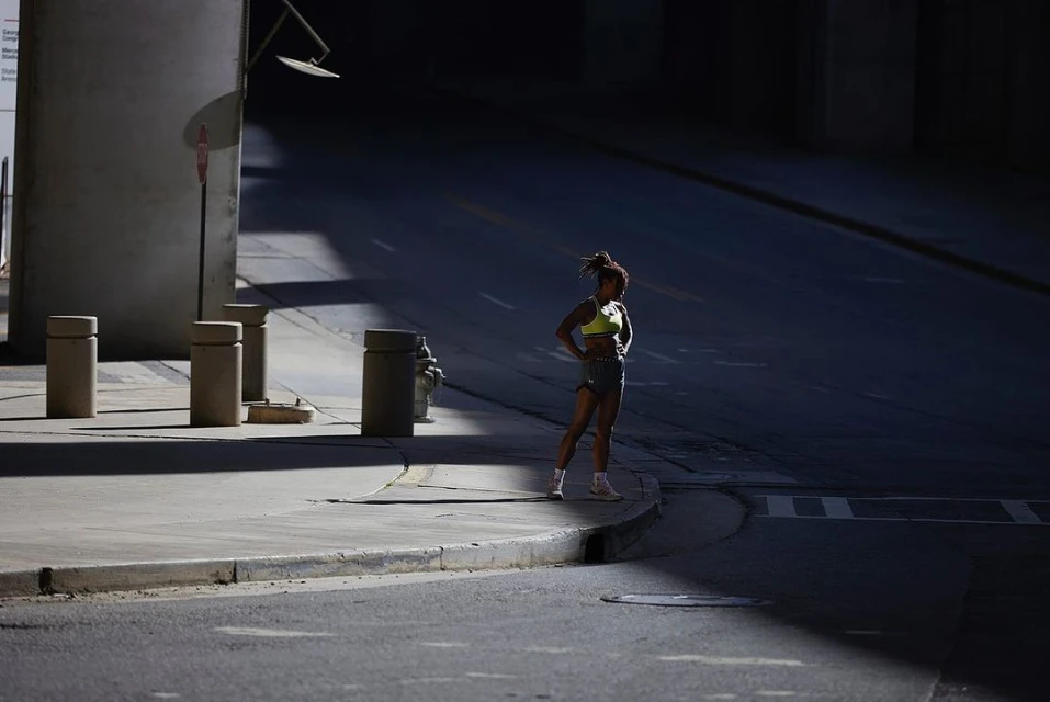 Athletic woman stands in street athletic wear, urban environment, fitness concept, healthy lifestyle, health and wellness.