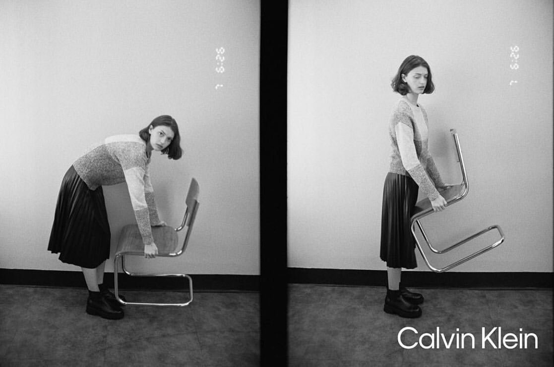 Split frame of a woman in a patterned sweater and dark pleated skirt holding a metal chair by photographer James Brodribb.