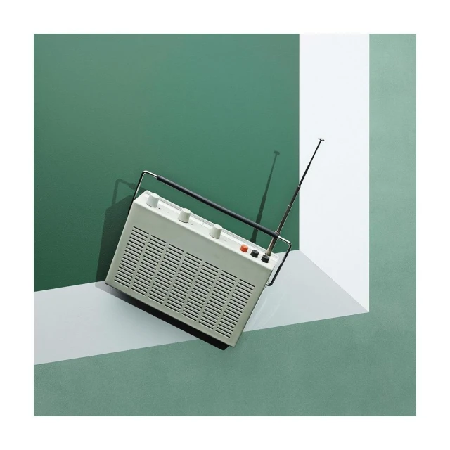 Retro-style radio receiver set against a modern green and white geometric background, emphasizing a blend of vintage and contemporary aesthetics.