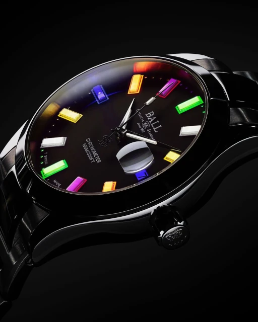Close-up of a black Ball wristwatch with colorful hour markers on a dark background, showcasing its design and features.