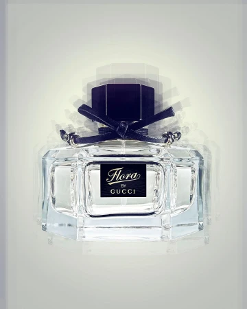 Clear glass perfume bottle with black cap and black bow. The bottle has a black label with the brand name Flora by Gucci.