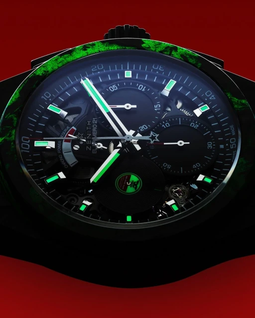 Close-up of a luxury wristwatch with a black dial, green accents, and intricate details, set against a red background.